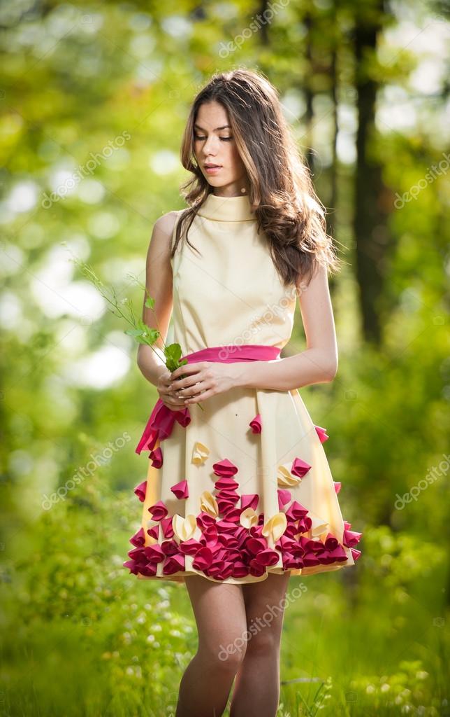 Young beautiful girl in a yellow dress in the woods. Portrait of ...