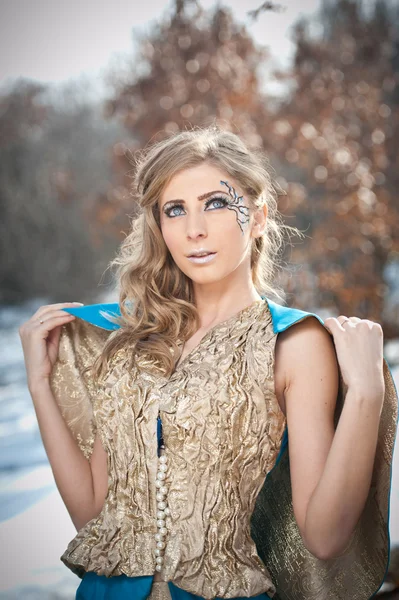 Mooie jonge dame in elegante jurk poseren winter landschap, Koninklijke kijken. modieuze blonde vrouw met bos in achtergrond, buiten schieten. glamoureuze vrouw met lang eerlijke haren in de natuur - prinses stijl — Stockfoto