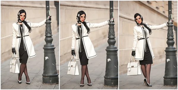 Aantrekkelijke jonge vrouw in winter mode schot. Mooi modieuze jonge meisje in zwart-wit outfit die zich voordeed op avenue. Elegante brunette met hoofddoek, zonnebril en handtas in stedelijke omgeving. — Stockfoto