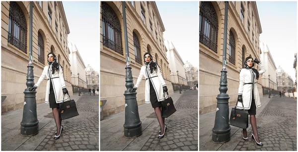 Attractive young woman in winter fashion shot. Beautiful fashionable young girl in black and white outfit posing on avenue. Elegant brunette with headscarf, sunglasses and handbag in urban scenery. — Stock Photo, Image