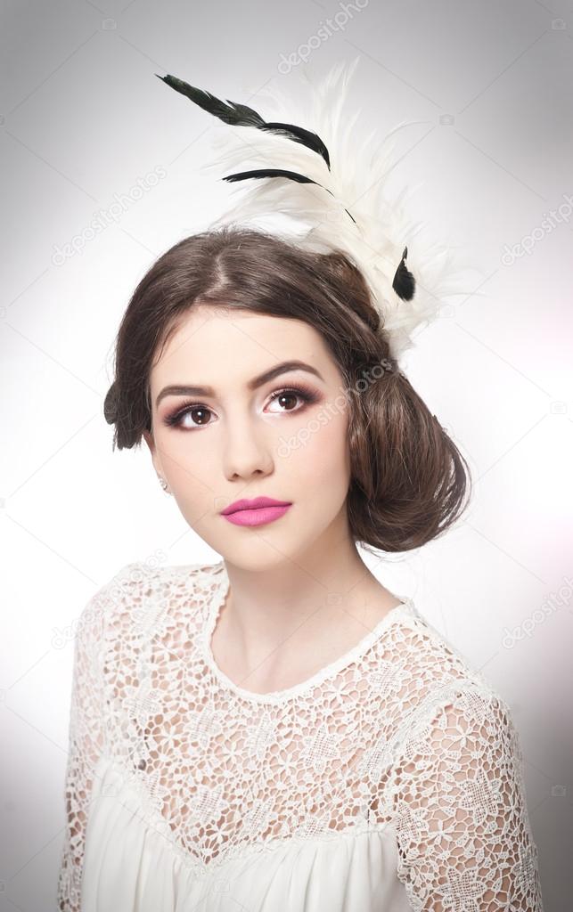Hairstyle and make up - beautiful young girl art portrait. Genuine natural brunette with creative haircut, studio shot. Attractive female with beautiful lips and eyes in white lace blouse, over white
