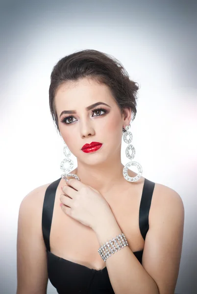 Hairstyle and make up - beautiful female art portrait with beautiful eyes. Elegance. Genuine natural brunette with jewelry in studio. Portrait of a attractive woman with red lips and creative make up — Stock Photo, Image