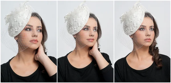 Penteado e compõem - belo retrato de arte jovem. Morena bonito com tampa branca e véu, tiro estúdio. Mulher atraente com belos lábios e olhos em blusa preta, sobre branco — Fotografia de Stock