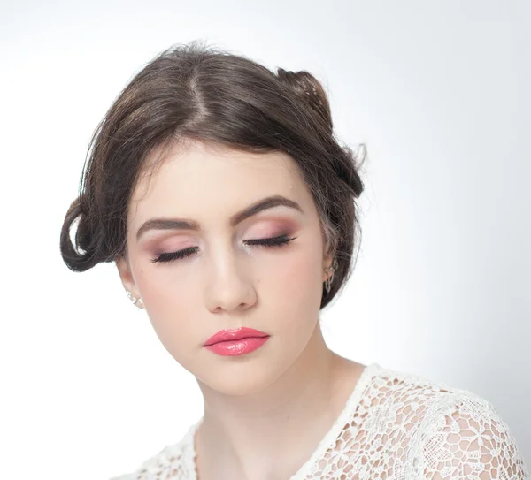 Penteado e compõem - belo retrato de arte de menina com olhos fechados. Morena natural genuína, tiro estúdio. Mulher atraente com lábios bonitos em blusa de renda branca, sobre fundo branco — Fotografia de Stock