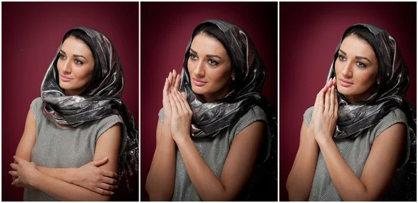 Attractive brunette woman in gray blouse and headscarf posing dramatic on purple background. Female art portrait, studio shot. Genuine natural girl with sad smile. Woman in Virgin Mary pose — Stock Photo, Image