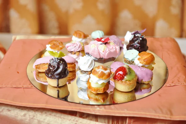 Svatební dekorace s barevnými koláčky, pusinky a muffiny. Elegantní a luxusní událostí uspořádání s barevné koláče. Svatební moučník. Sada mini chutné koláče na stole — Stock fotografie