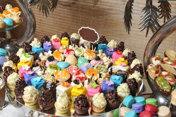 Bruiloft decoratie met pastel gekleurde cupcakes, schuimgebakjes, muffins en macarons. elegante en luxueuze gebeurtenis regeling met kleurrijke bitterkoekjes. bruiloft dessert met bitterkoekjes — Stockfoto