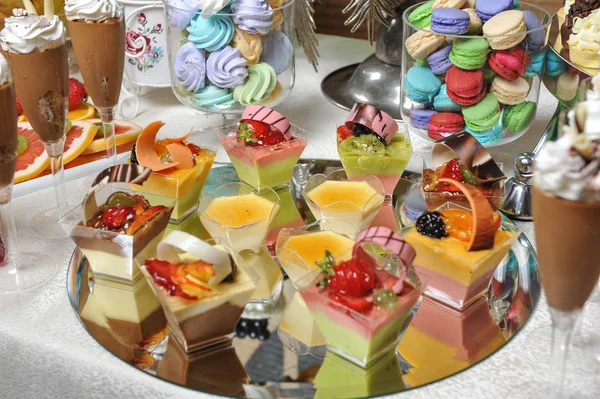 Bruiloft decoratie met pastel gekleurde cupcakes, schuimgebakjes, muffins en macarons. elegante en luxueuze gebeurtenis regeling met kleurrijke bitterkoekjes. bruiloft dessert met bitterkoekjes — Stockfoto