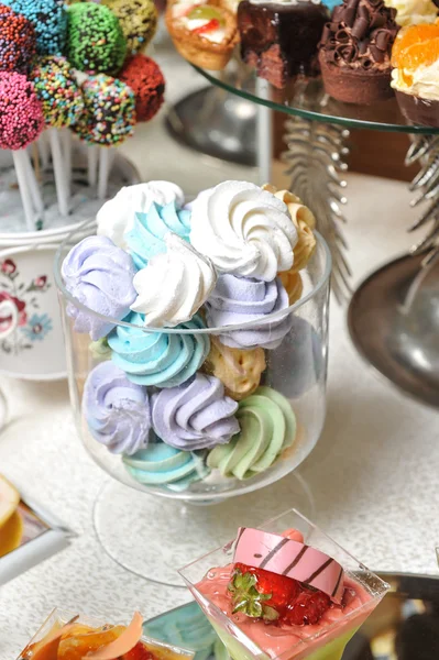 Bröllop dekoration med pastell färgade maränger, muffins, cupcakes och macarons. eleganta och lyxiga event arrangemang med färgglada macaroons. bröllop dessert med mandelbiskvier — Stockfoto