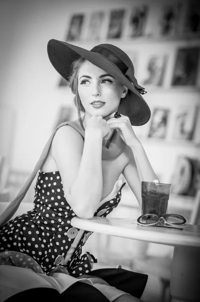 Señorita atractiva de moda con sombrero y bufanda sentado en el restaurante, tiro interior. Mujer joven posando en un paisaje elegante, blanco y negro. Foto de arte de mujer sensual elegante relajante, estilo vintage — Foto de Stock