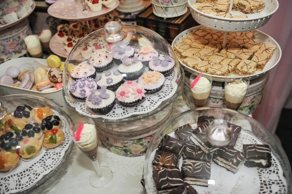 Decoração de casamento com cupcakes coloridos pastel, merengues, muffins e macarons. Arranjo de evento elegante e luxuoso com macaroons coloridos. Sobremesa de casamento com macaroons — Fotografia de Stock
