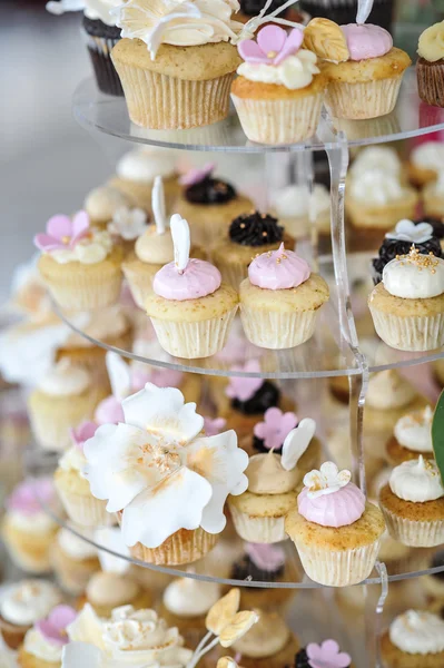 Svatební dekorace s pastelově barevné koláčky, pusinky, muffiny a macarons. elegantní a luxusní událostí uspořádání s barevnými makaróny. Svatební moučník s makaróny — Stock fotografie