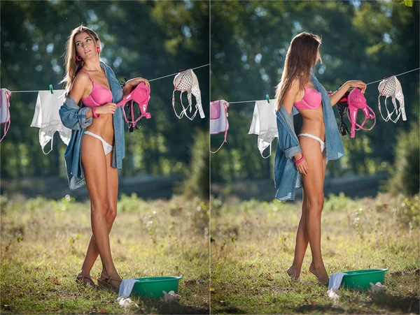 Sexy brunette woman in bikini and shirt putting clothes to dry in sun. Sensual young female with long legs putting out the washing to dry in sunny day. Perfect body housewife, outdoor shot in forest — Stock Photo, Image