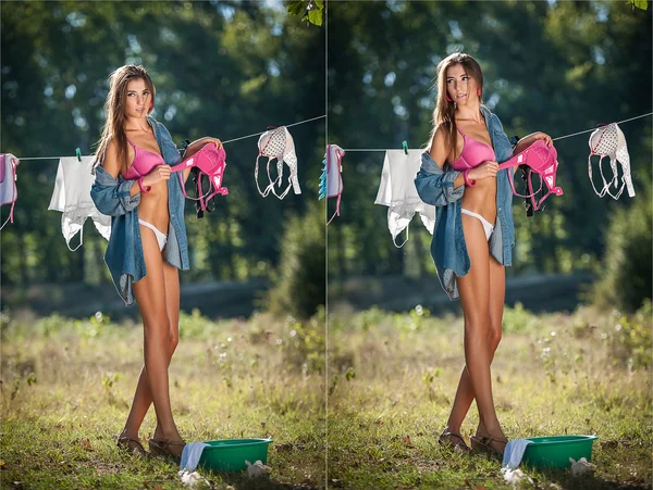 Sexy brunette woman in bikini and shirt putting clothes to dry in sun. Sensual young female with long legs putting out the washing to dry in sunny day. Perfect body housewife, outdoor shot in forest — Stock Photo, Image