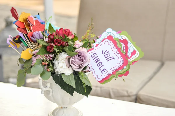 Mazzo di fiori freschi multicolore e decorazioni di carta in un vaso su un tavolo e tag con parole ancora singole. Sistemazione tavola nuziale per partecipanti singoli — Foto Stock