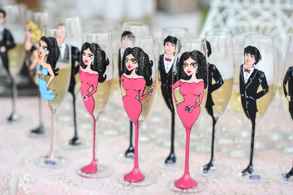 Wedding decor, wine glasses and champagne flutes on table. Champagne flutes painted as women and men. Festive wedding glasses with decor — Φωτογραφία Αρχείου
