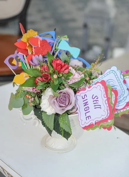 Multicolor flores frescas ramo y decoraciones de papel en un jarrón en una mesa y etiqueta con palabras todavía solo. Arreglo de mesa de boda para participantes individuales —  Fotos de Stock