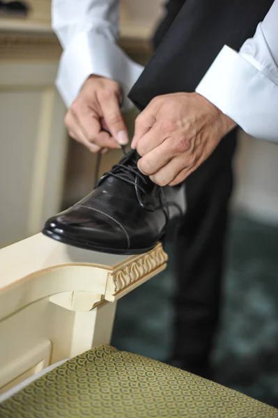 El padrino se prepara para un día especial. Un novio que se pone zapatos mientras se viste con ropa formal. Traje de novio —  Fotos de Stock