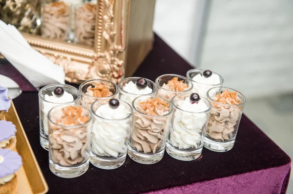 Wedding decoration with pastel colored sweets in small glasses. Elegant and luxurious event arrangement with cookies. Wedding dessert cocoa cream and vanilla cream candies — Stock Photo, Image