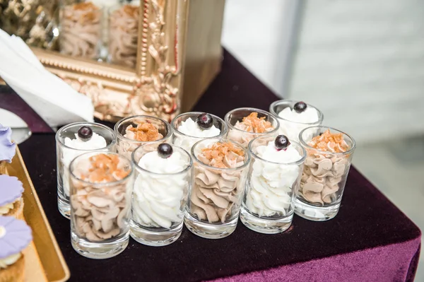 Hochzeitsdekoration mit pastellfarbenen Süßigkeiten in kleinen Gläsern. elegantes und luxuriöses Veranstaltungsarrangement mit Cookies. Hochzeitsdessert Kakaocreme und Vanillecreme Bonbons — Stockfoto