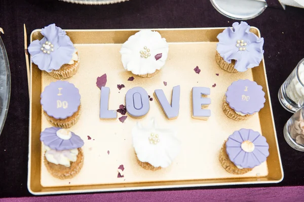 Bruiloft decor, Love letters op dienblad met blauw gekleurde muffins. Hou van decoratie op feestelijke tabel. Luxe bruiloft decoratie op restaurant tabel. Elegante gebeurtenis — Stockfoto