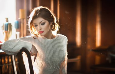 Pencere arka planda oturan genç şehvetli kadın. Beyaz rahat bluz hayal kapalı, rahat ile güzel kız. Çekici esmer sandalyede poz yaratıcı bir makyaj