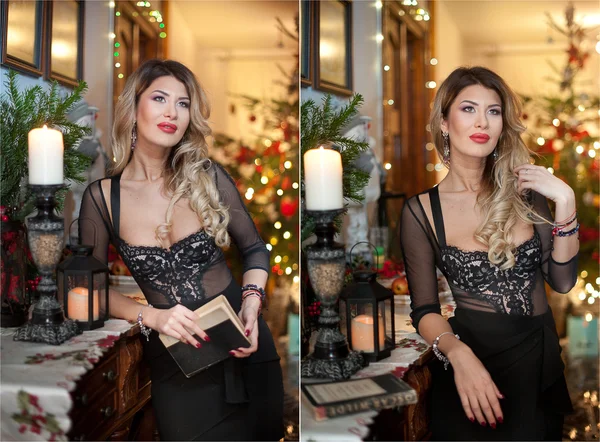 Mulher sexy bonita em vestido preto elegante com árvore de Natal no fundo. Retrato de menina loira na moda segurando um livro perto de decorações de Natal. Cabelo claro atraente leitura feminina interior — Fotografia de Stock