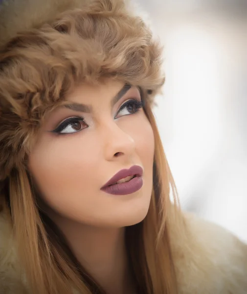 Attractive young Caucasian adult with brown fur cap. Beautiful blonde girl with gorgeous lips and eyes wearing fur hat, outdoor shot. Makeup - sensual long fair hair female art portrait, winter season — Stok fotoğraf