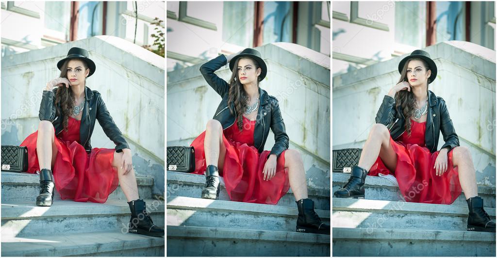 Beautiful woman with black hat, red dress and boots posing sitting on stairs. Young brunette spending time during autumn. Long hair attractive girl with creative makeup and red dress, outdoors shot
