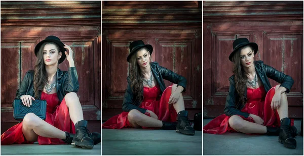 Young beautiful brunette woman with red short dress and black hat posing sensual in vintage scenery. Romantic mysterious young lady relaxing sitting on floor against vintage wooden wall — Stock Photo, Image