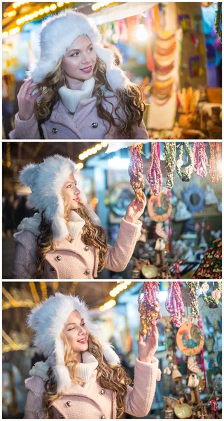 Mujer joven con gorra de piel blanca admirando accesorios en el mercado de Navidad, noche fría de invierno. Hermosa chica rubia en ropa de invierno con luces de Navidad en el fondo. Linda hembra sonriendo, paisaje de invierno — Foto de Stock