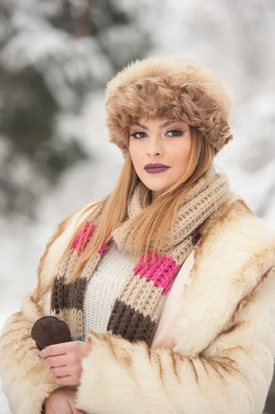 Attractive young Caucasian adult with brown fur cap. Beautiful blonde girl with gorgeous lips and eyes wearing fur hat, outdoor shot. Makeup - sensual long fair hair female art portrait, winter season — Stok fotoğraf