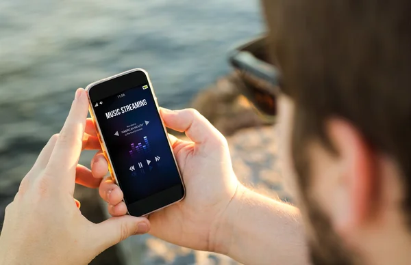 Man using smartphone on coast — Stock Photo, Image