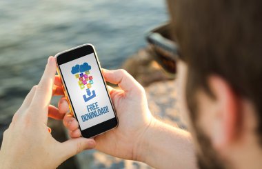 Kıyısında cep telefonu kullanan adam