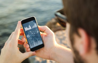 Kıyısında cep telefonu kullanan adam