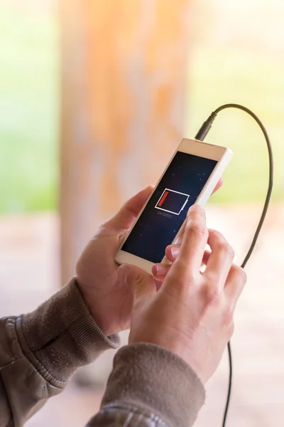 Hands holding smartphone with low battery — Stock Photo, Image