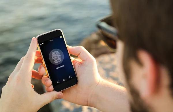 Muž na pobřeží odemknutí telefonu — Stock fotografie