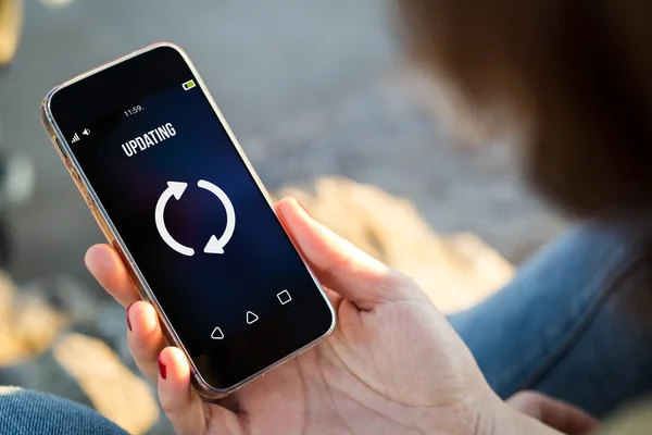 Woman updating mobile phone — Stock Photo, Image