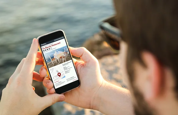 Man using phone to search on online directory — Stock Photo, Image