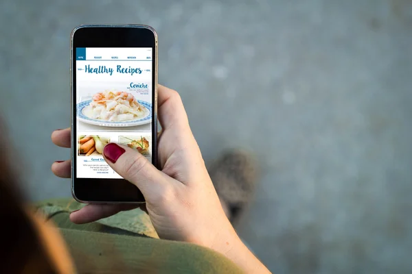 Woman using phone to watch video recipes — Stock Photo, Image