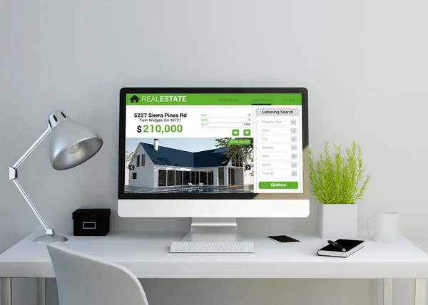 Spazio di lavoro con sito web immobiliare sullo schermo — Foto Stock