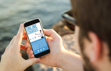 Kıyısında cep telefonu kullanan adam