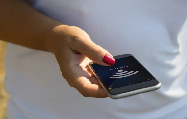 Mujer con wifi gratuito en la pantalla del teléfono inteligente —  Fotos de Stock