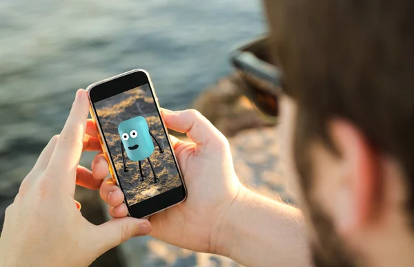 Man on coast using smartphone — Stock Photo, Image