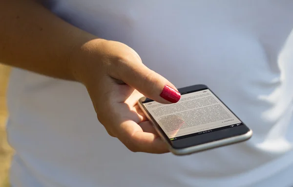 Frau berührt Smartphone mit eBook — Stockfoto