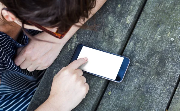 Frau benutzt Smartphone über Tisch — Stockfoto
