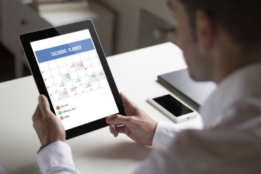 tablet planlayıcısı gösterilen tutan işadamı