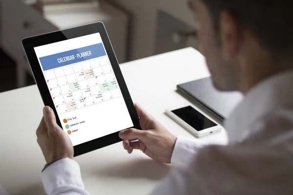 Бизнесмен держит планшет показывая планировщик — стоковое фото