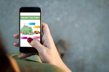 Smartphone akıllı fabrika denetimi yürüyen kadın