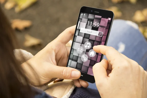 Vrouw met touchscreen telefoon in het park — Stockfoto